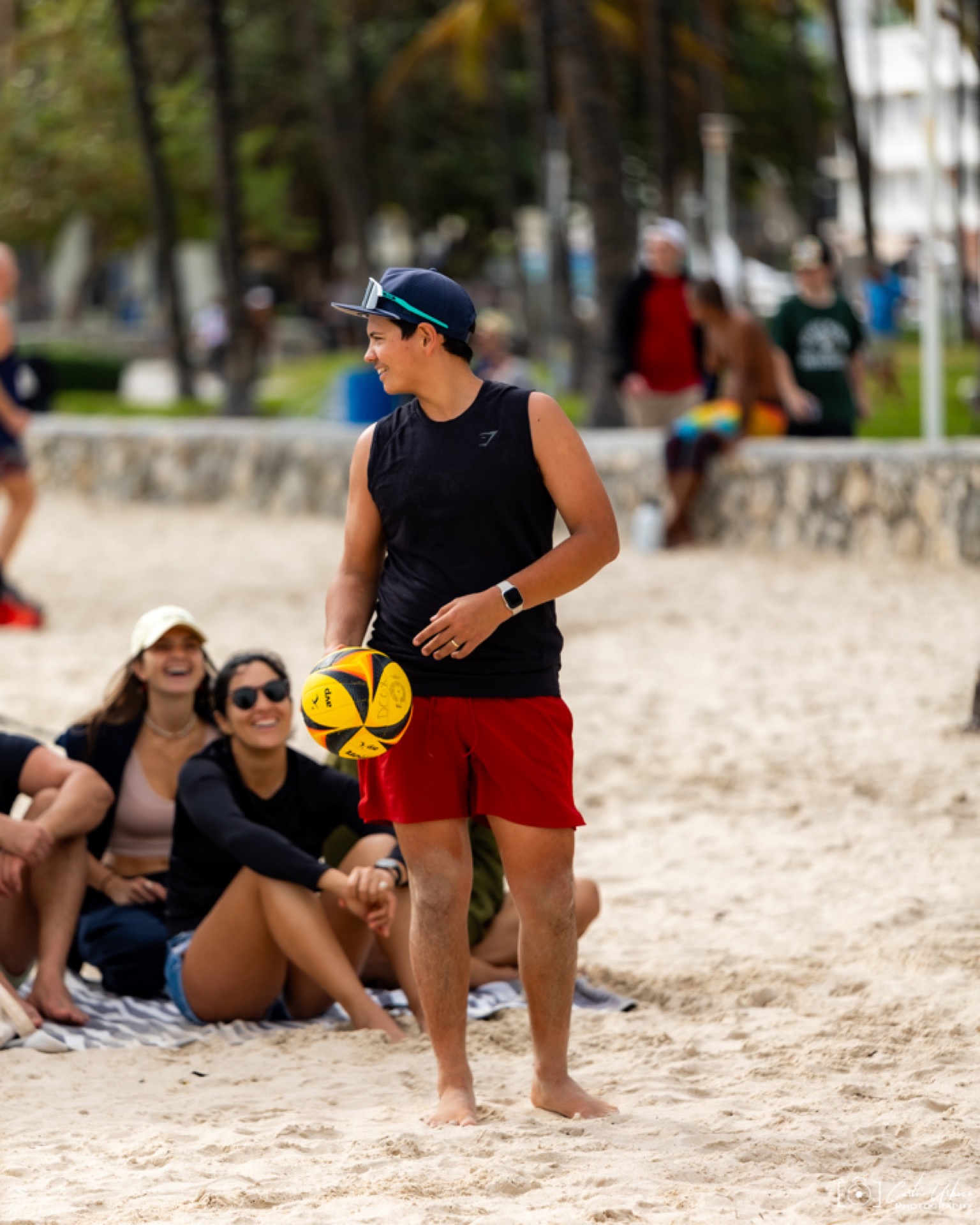 Brandon Lozano on the beach in Miami, holding a volleyball, in his element